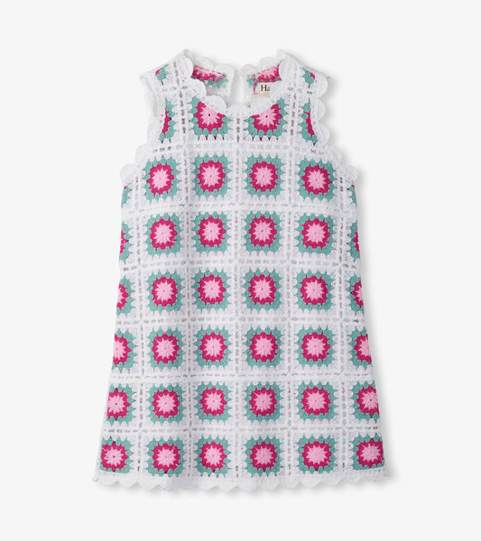 Sleeveless white crochet dress with pink and teal square floral pattern, front view