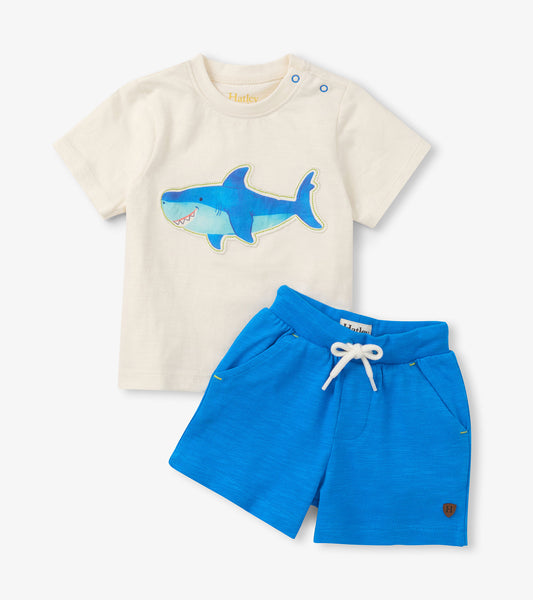Cream short-sleeve T-shirt with blue shark graphic and bright blue shorts with white drawstring, front view