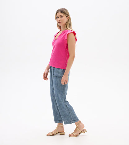 Bright pink sleeveless V-neck tank top with flutter sleeves, shown on a model in side view.