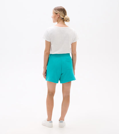 Turquoise high-waisted shorts with rolled hems and back patch pocket, shown from the back on a model