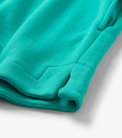 Close-up of folded turquoise knit shorts hem with stitched cuff detail