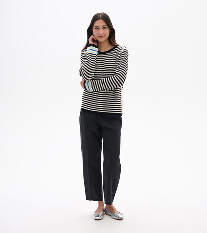 Front view of black and white striped pointelle sweater with black trim and blue cuff accents