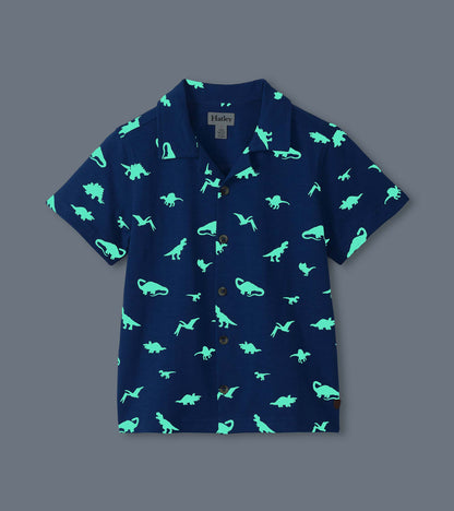 Navy short-sleeve button-down shirt with glowing teal dinosaur print, front view