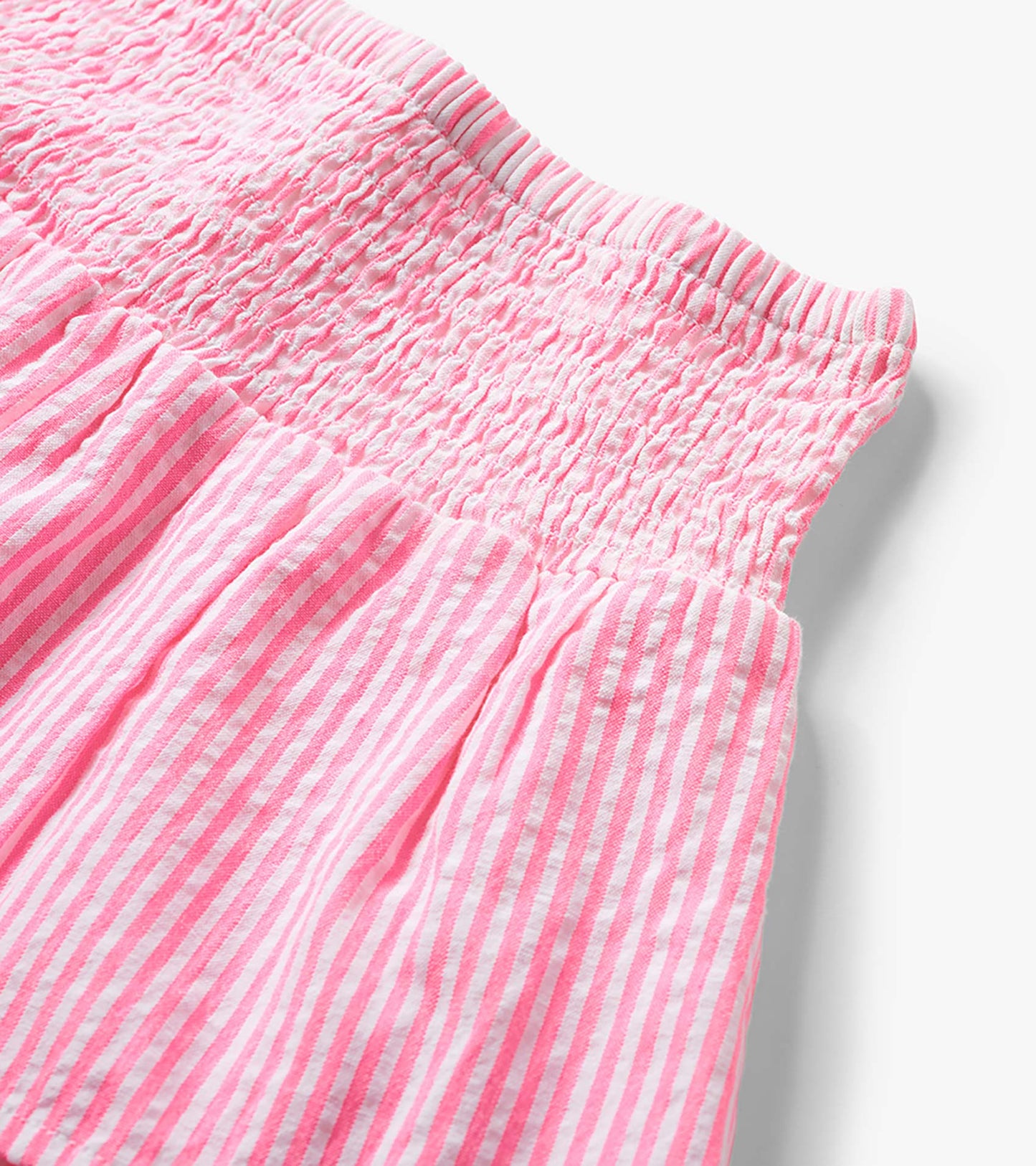 Neon pink and white striped seersucker skirt with smocked waistband, close-up detail view