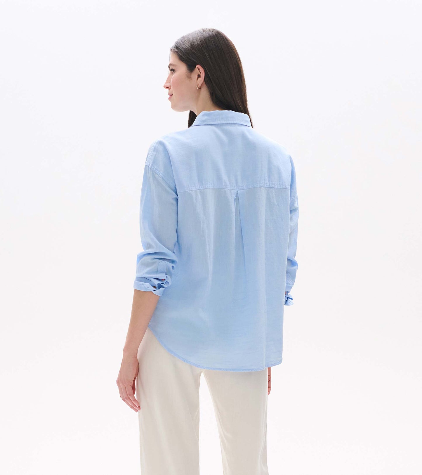 Light blue chambray button-down shirt shown from the back, with rolled sleeves and a relaxed fit