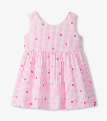 Sleeveless pink gingham toddler dress with small strawberry motifs and a gathered skirt, front view