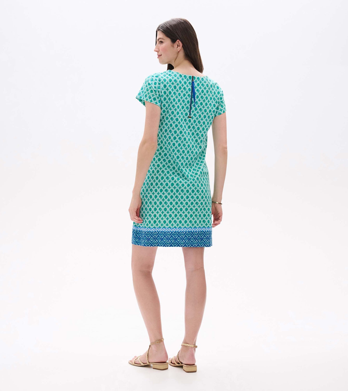 Back view of green and white medallion print tee dress with blue back zipper and blue border hem
