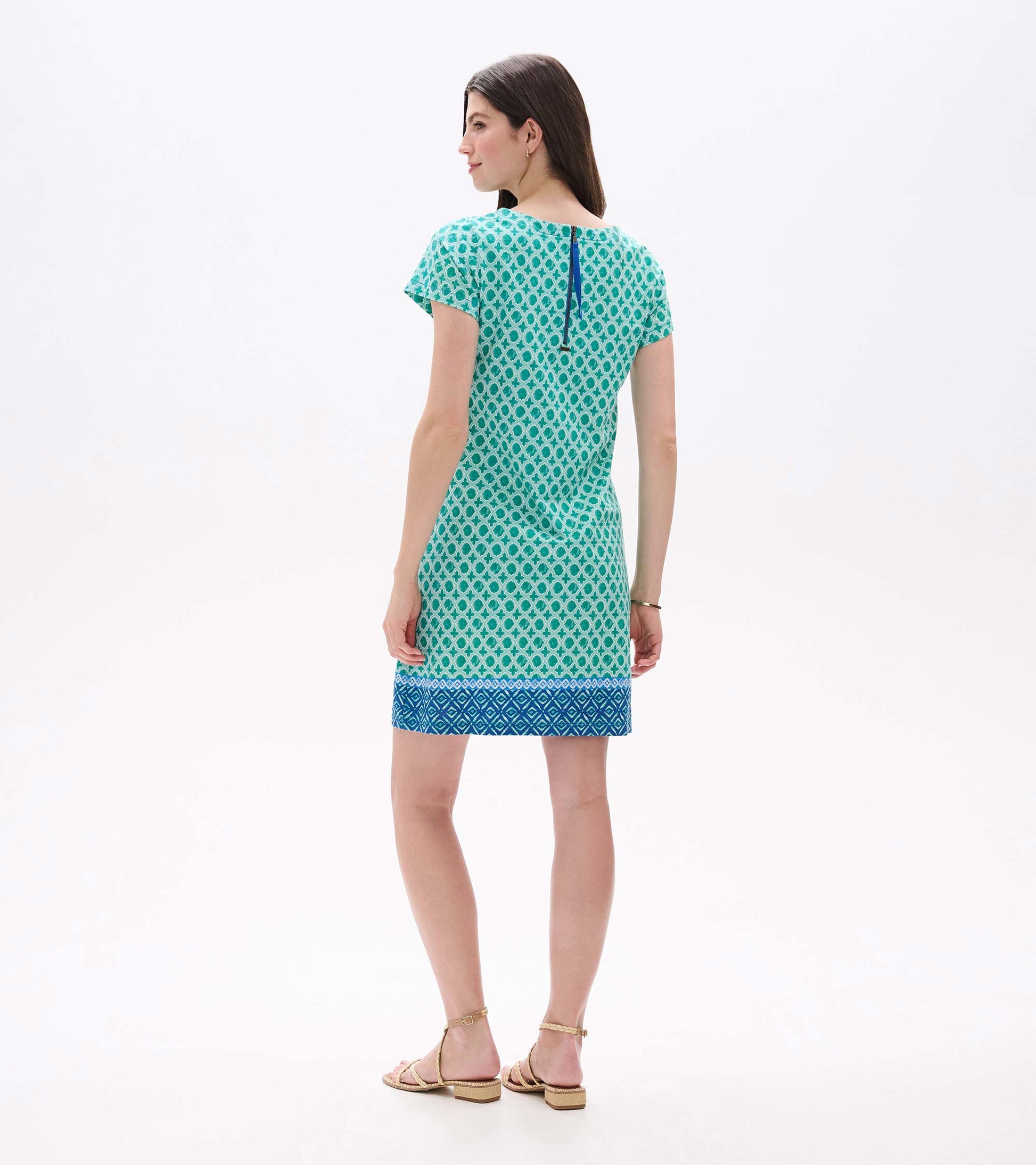 Back view of green and white medallion print tee dress with blue back zipper and blue border hem