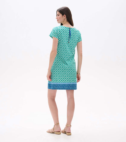 Back view of green and white medallion print tee dress with blue back zipper and blue border hem