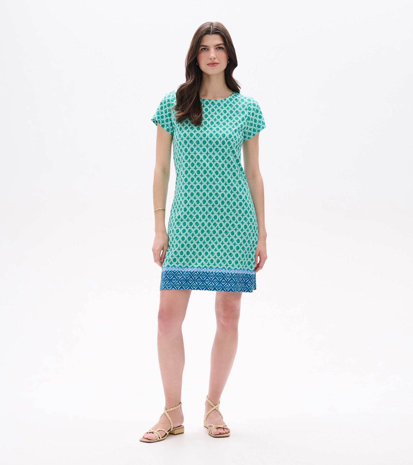 Front view of Arcadia Medallion tee dress with green geometric print, cap sleeves, and blue border hem