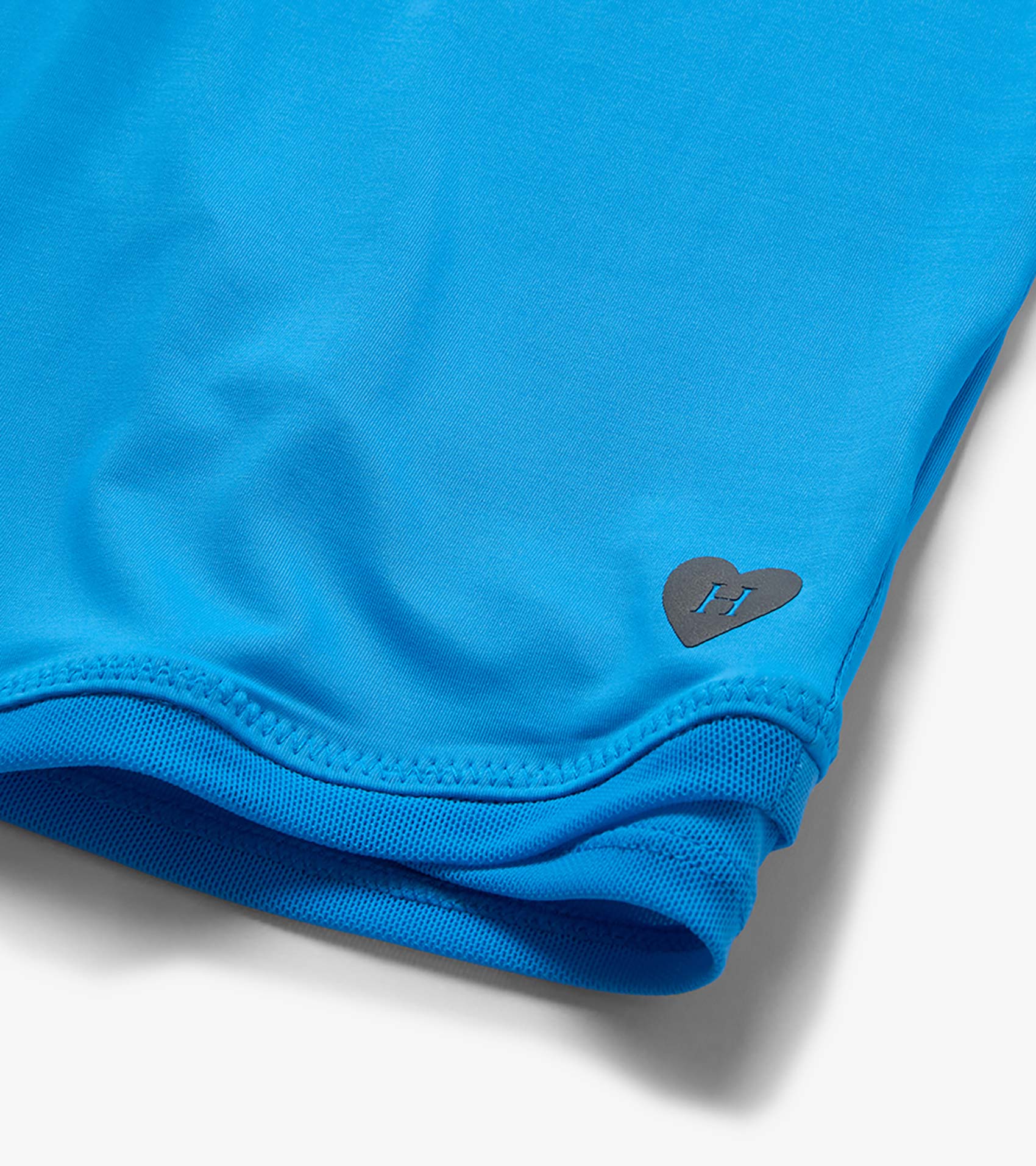 Bright blue girls' T-shirt with mesh trim at the hem and a small heart logo near the bottom hem