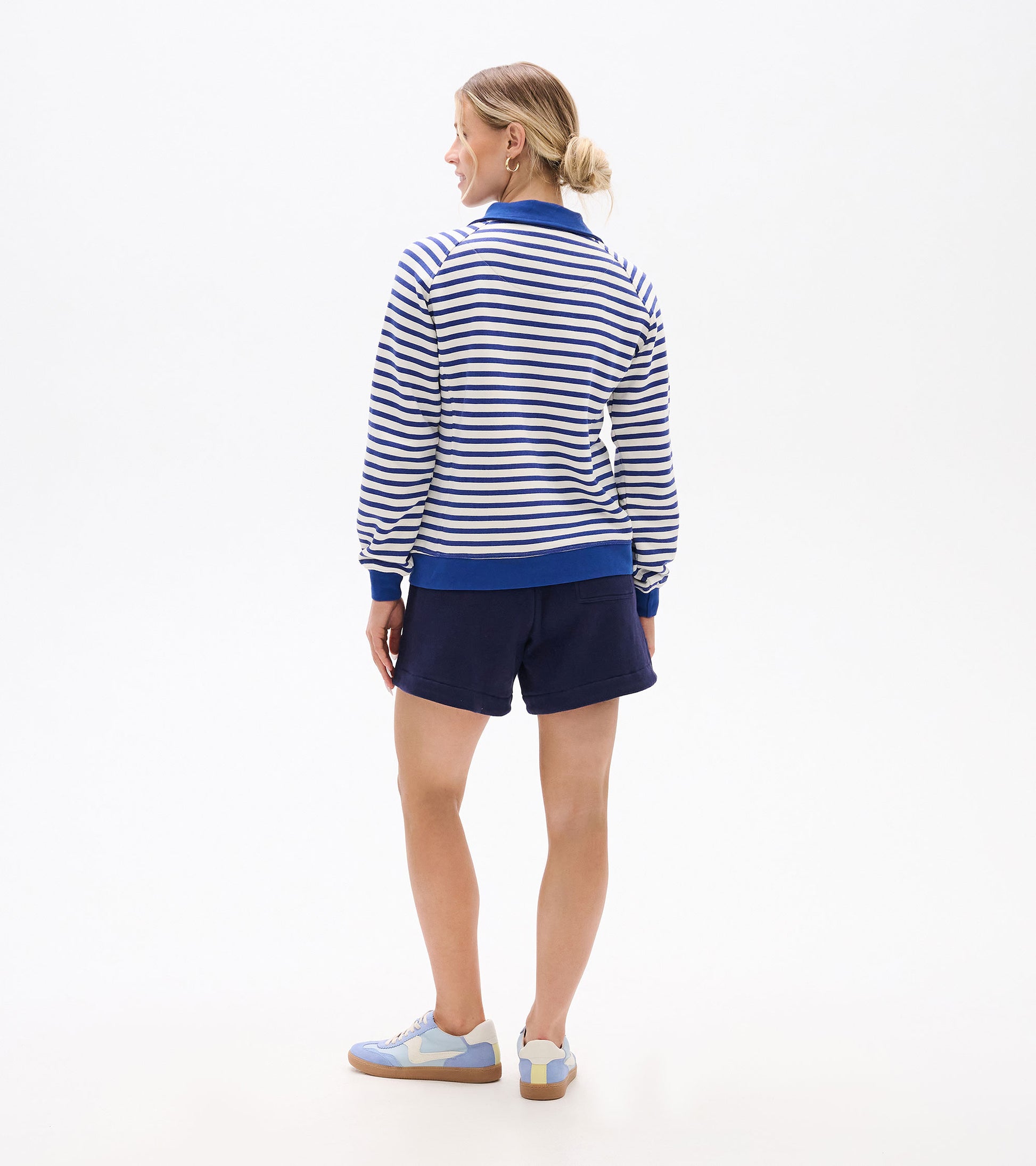 Back view of blue and white striped mock neck pullover with long sleeves and solid blue collar, cuffs, and hem