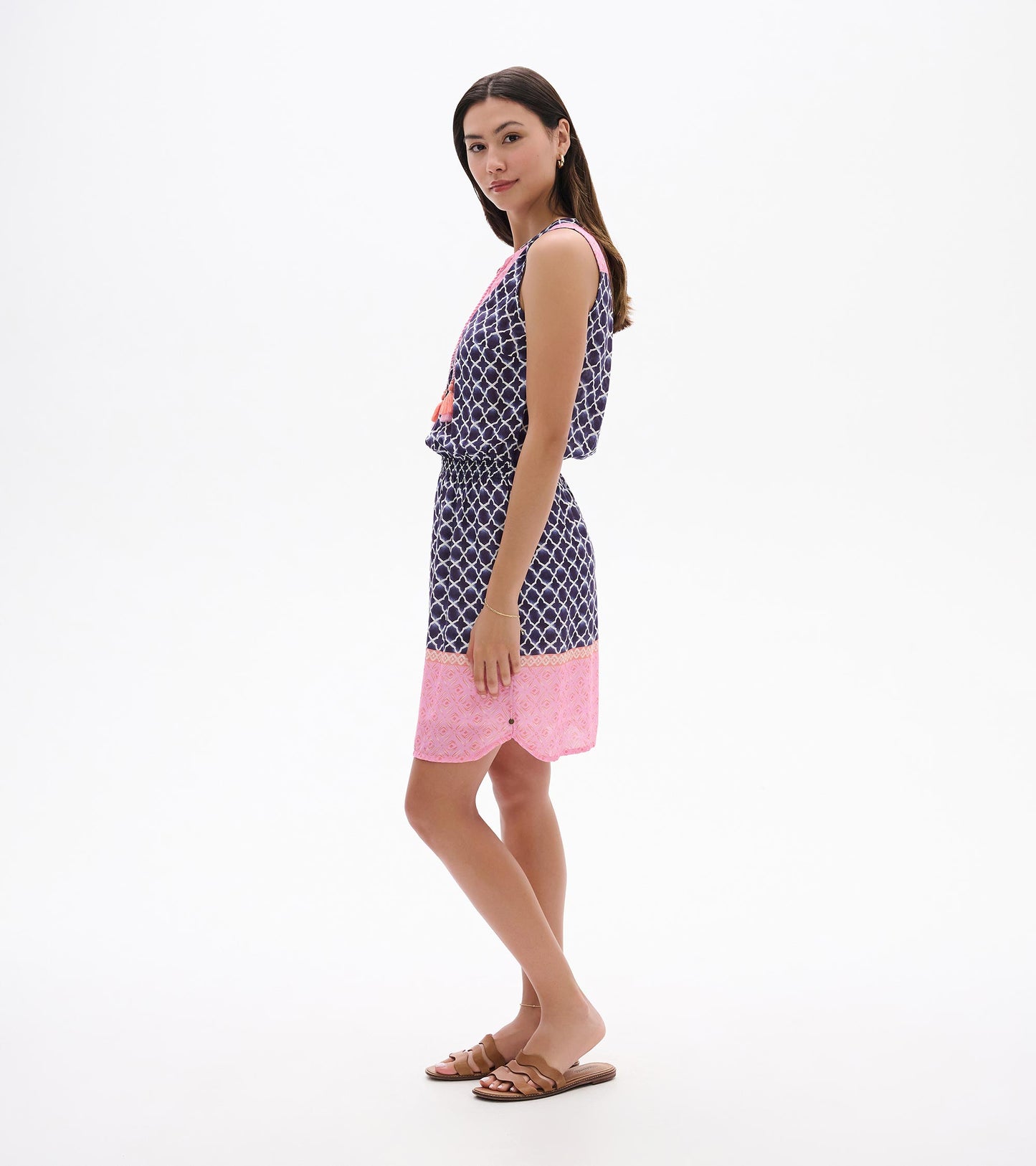 Sleeveless navy and pink patterned dress with tassel detail, shown in side view on a model