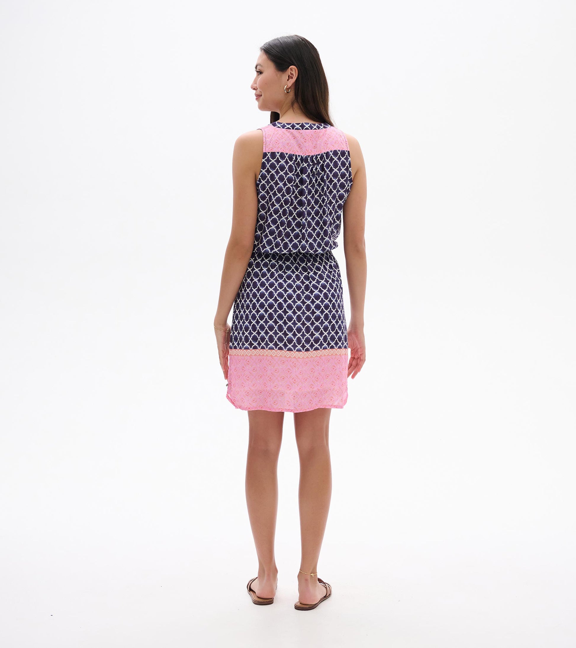 Back view of sleeveless navy and pink patterned dress with knee-length hem and waist tie