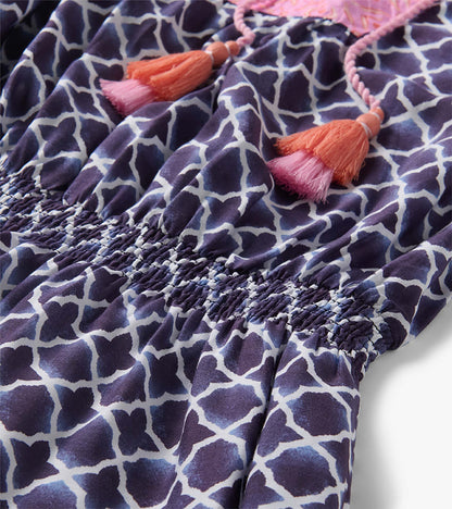 Navy and white patterned dress with pink and orange tassel ties and smocked waist detail