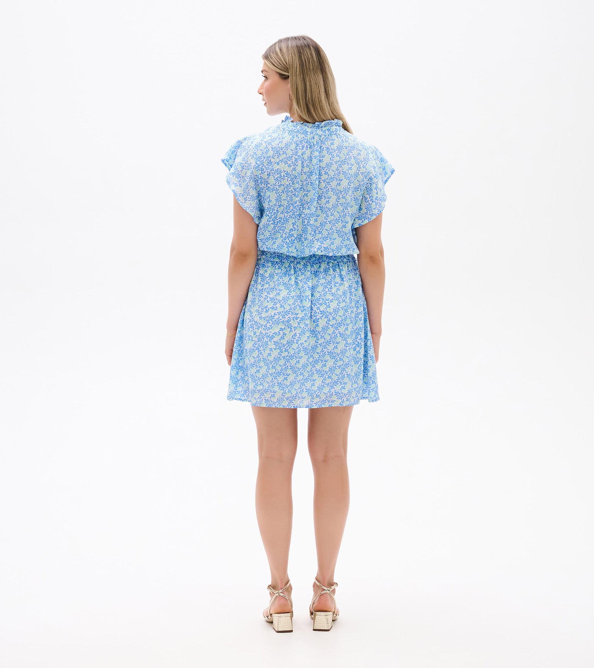Back view of Ava Dress in blue and soft green mini vine print with flutter sleeves and a smocked waist