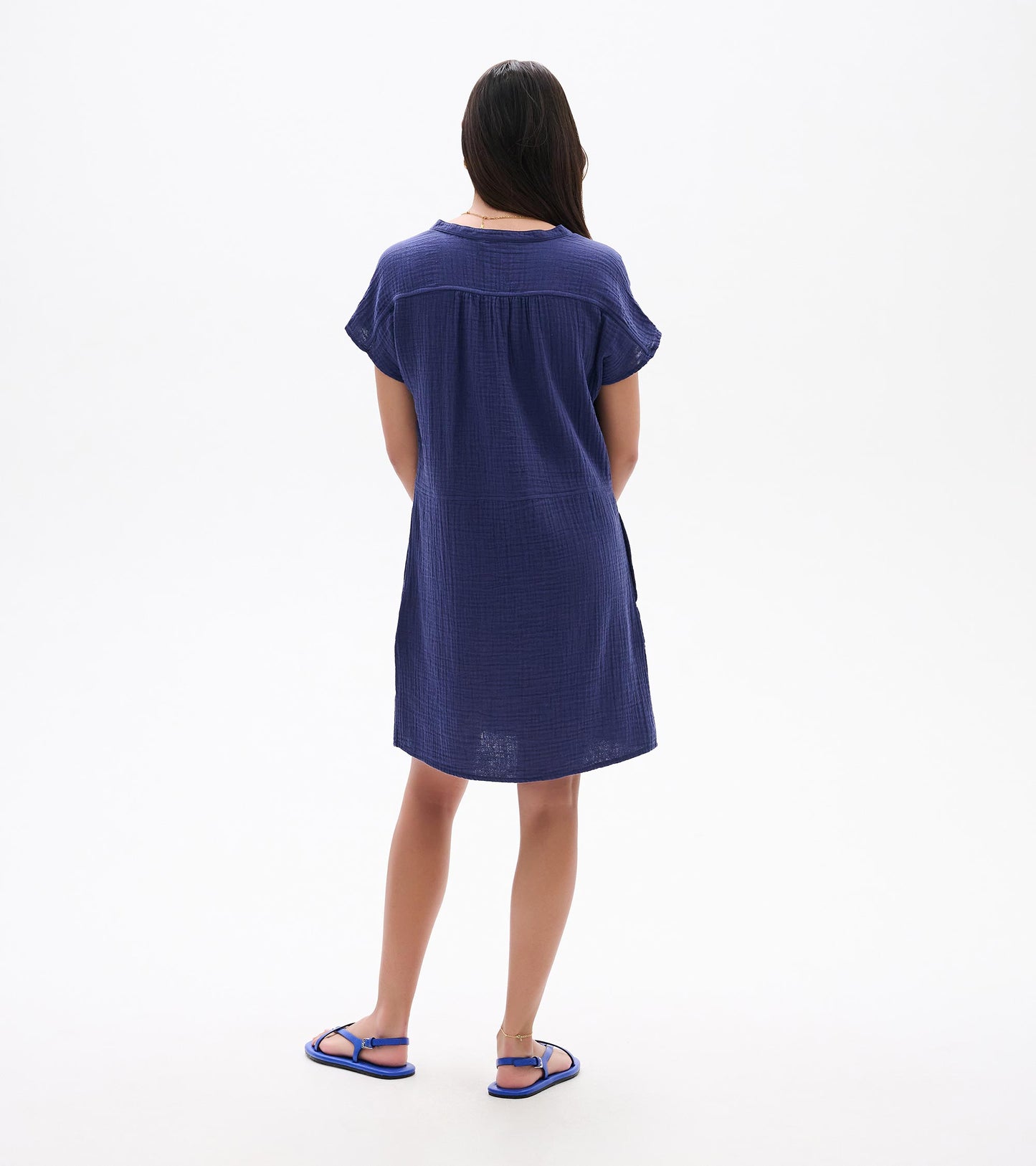 Back view of a navy blue short-sleeve knee-length dress with a loose fit and textured fabric