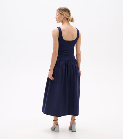 Back view of a navy sleeveless midi dress with fitted bodice and full gathered skirt