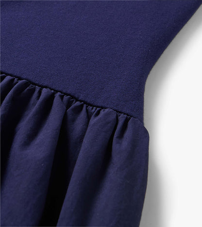 Close-up of a navy blue midi dress with a ribbed knit bodice and gathered skirt seam