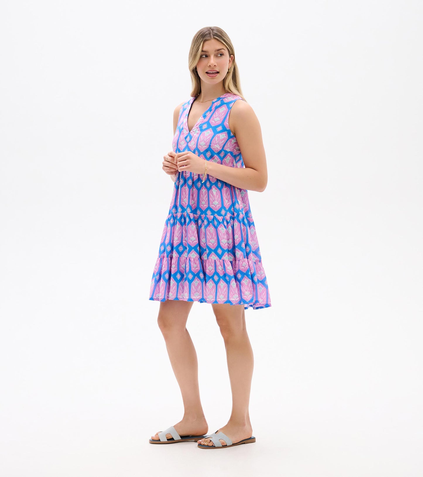 Sleeveless V-neck mini dress with blue, pink, and purple floral geometric print, tiered skirt, front view