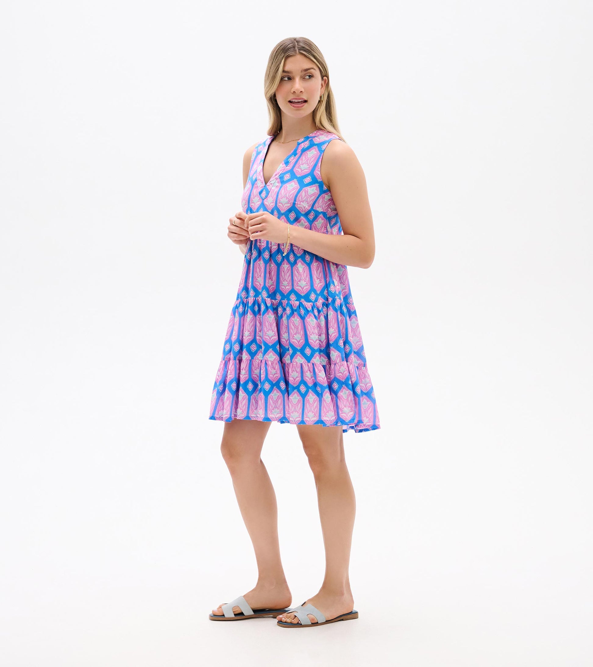 Sleeveless V-neck mini dress with blue, pink, and purple floral geometric print, tiered skirt, front view
