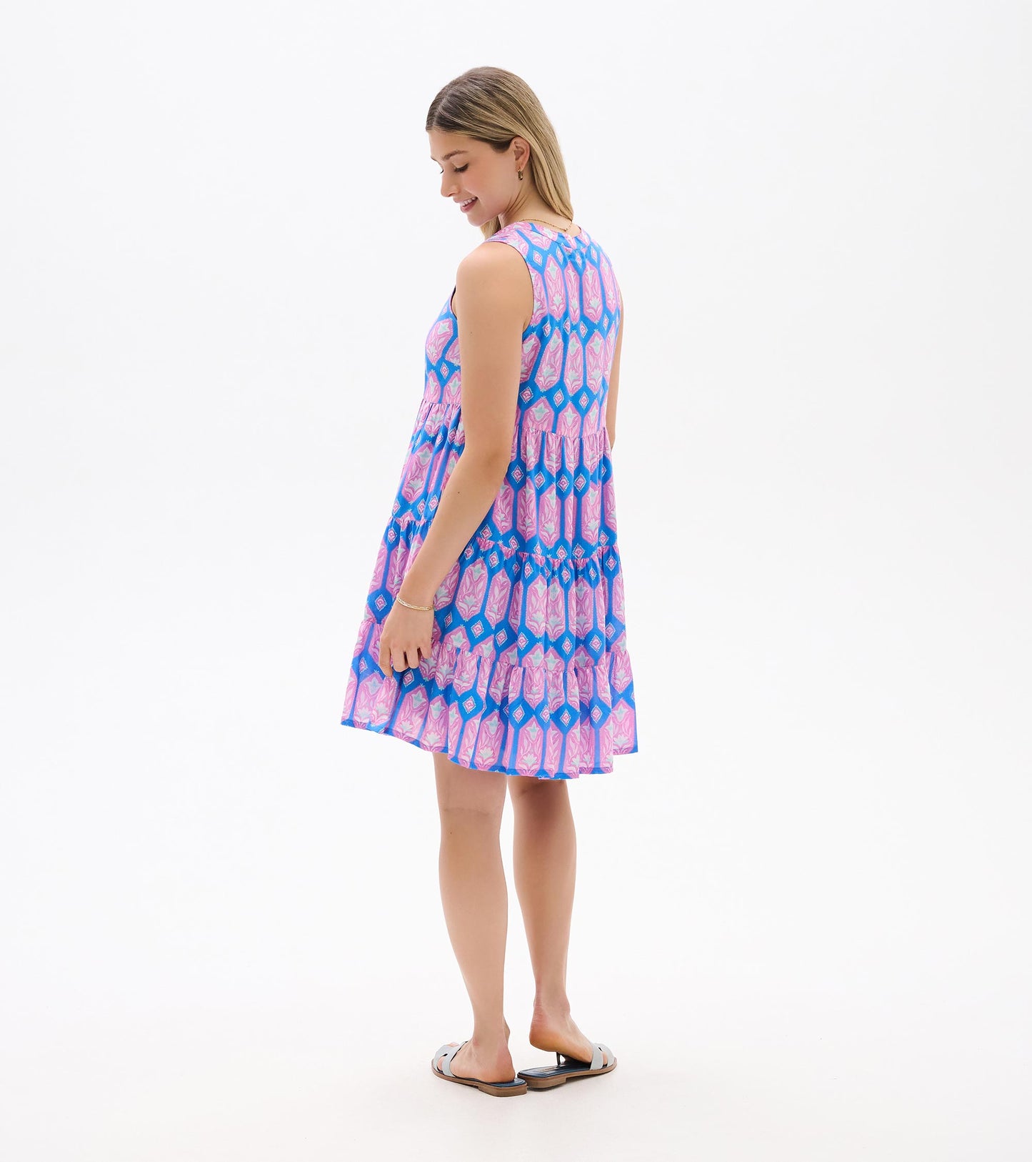 Sleeveless pink and blue patterned tiered dress, back view, knee length with a flared skirt