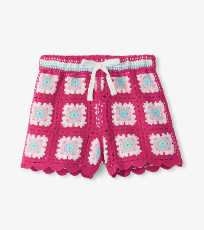 Girls pink crochet shorts with floral square pattern, white drawstring, and scalloped hem, front view