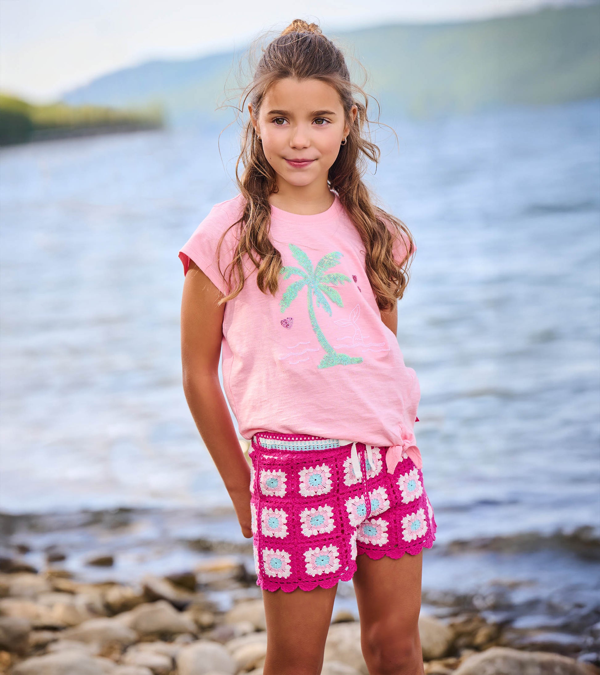 Girls pink crochet shorts with white and light blue floral squares, front view