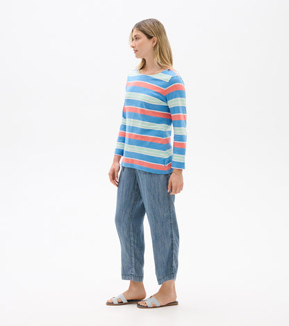 Woman wearing a blue, coral, and mint striped long-sleeve top with a boat neckline, side view