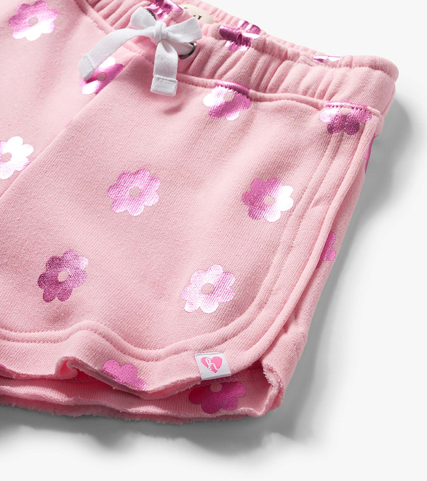 Pink girls pull-on shorts with white drawstring and pink floral print, close-up front view