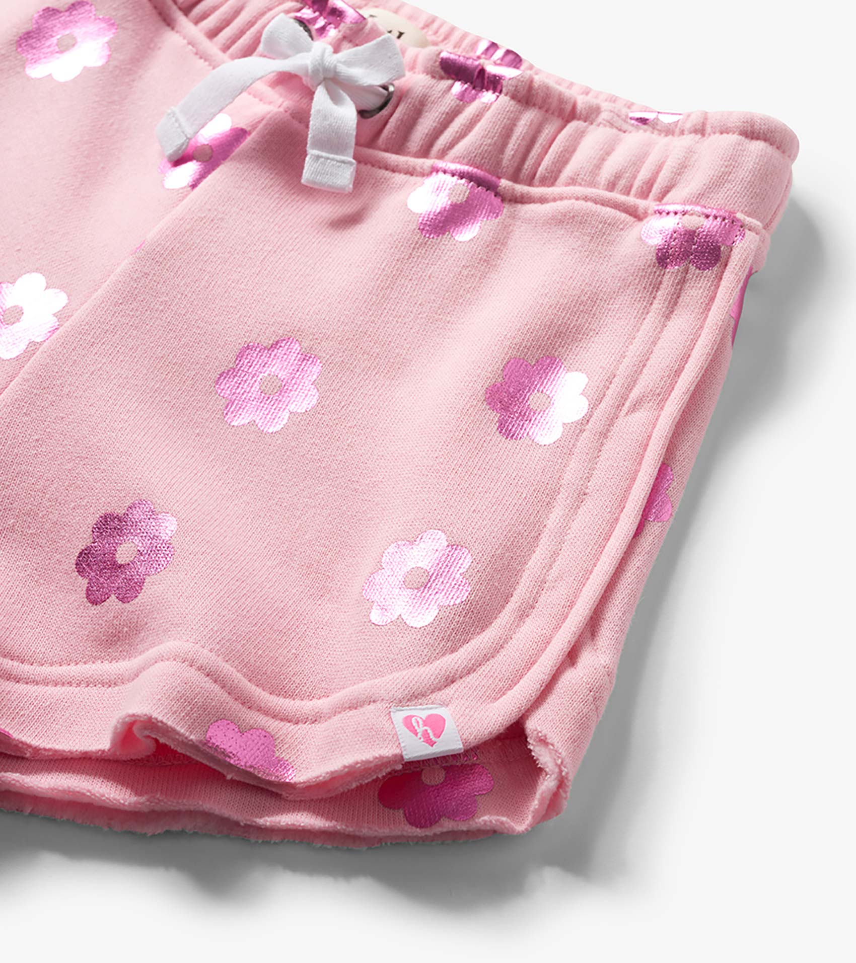 Pink girls pull-on shorts with white drawstring and pink floral print, close-up front view