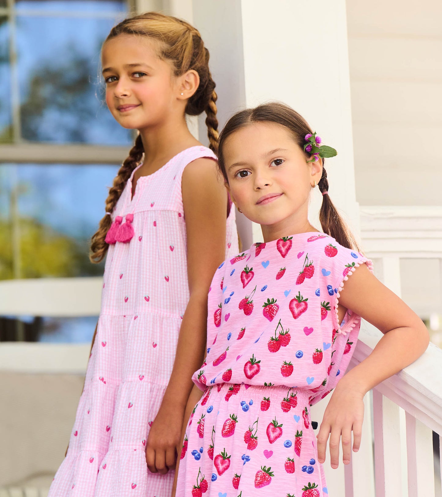 Girls pink berry-print smocked waist dress with sleeveless ruffled shoulders, front view on child model