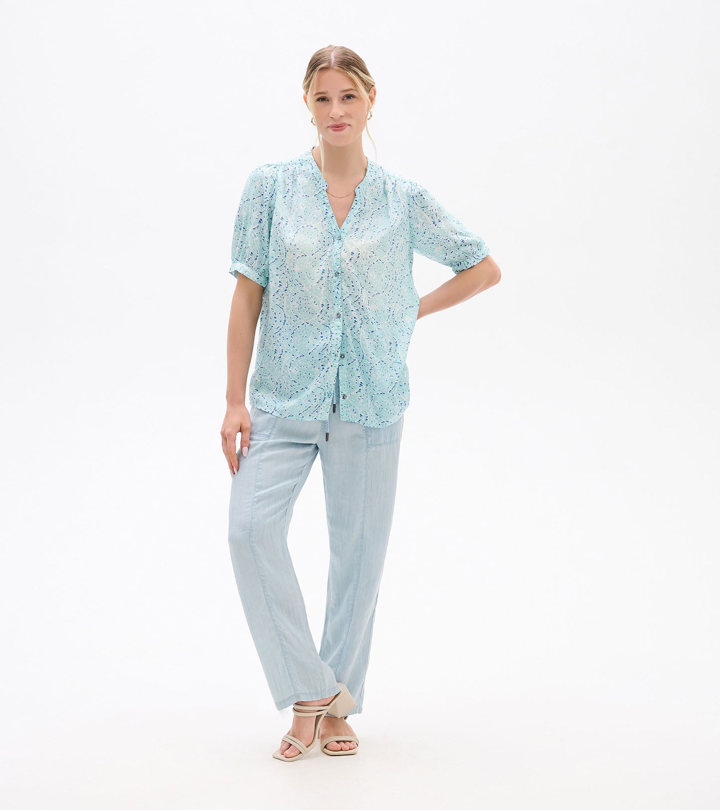 Light blue short-sleeve blouse with ikat print, button front and V-neck, worn on a model