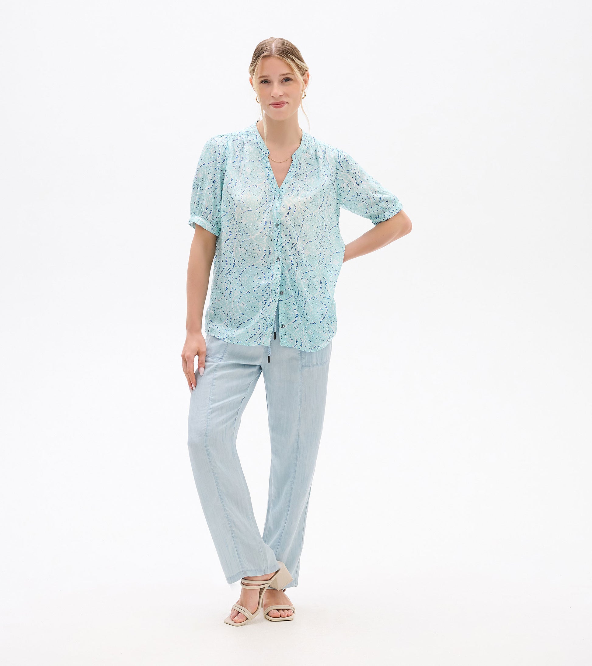 Light blue short-sleeve blouse with ikat print, button front and V-neck, worn on a model