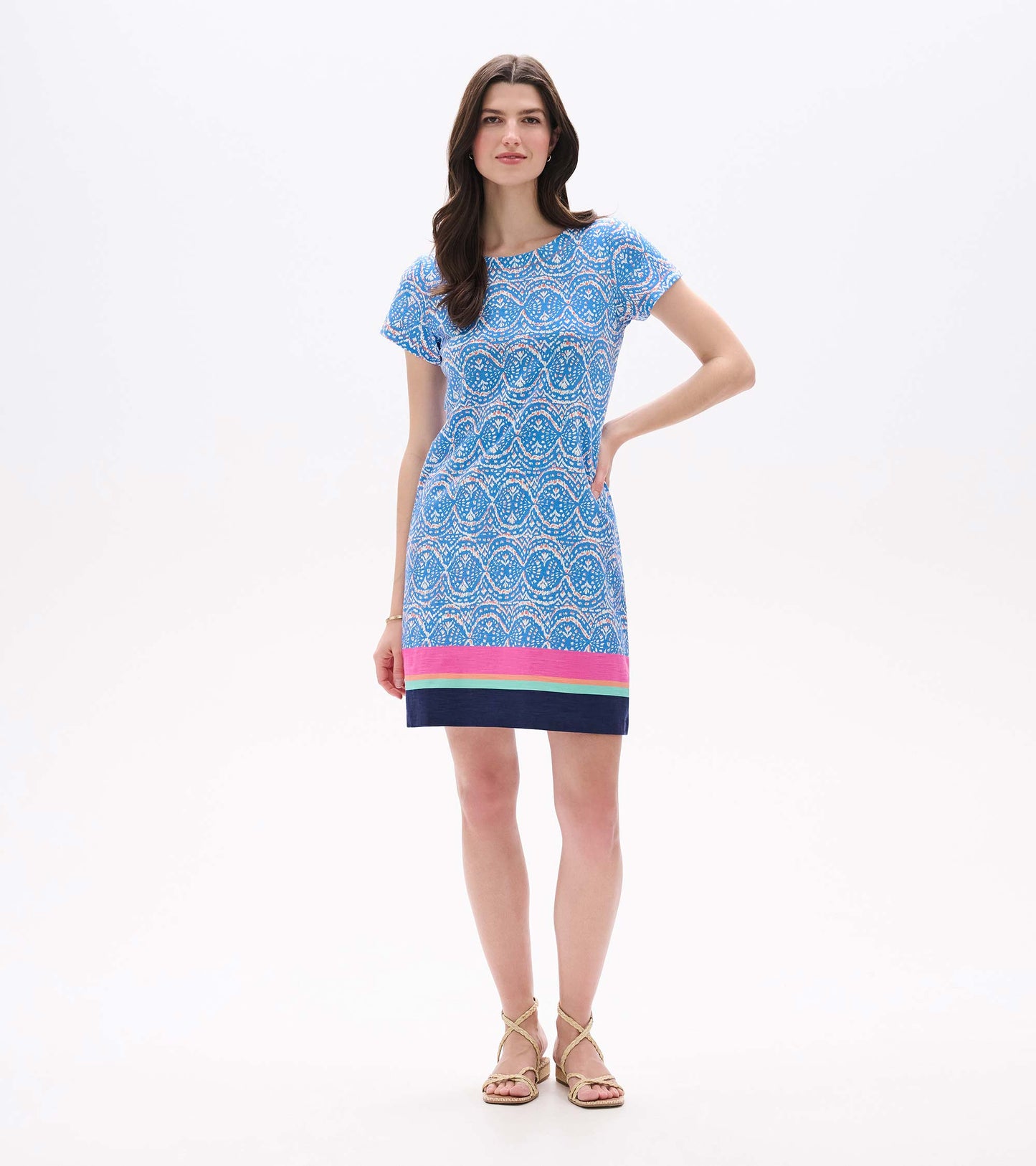 Front view of blue and white ikat tee dress with short sleeves and pink, aqua, and navy striped hem