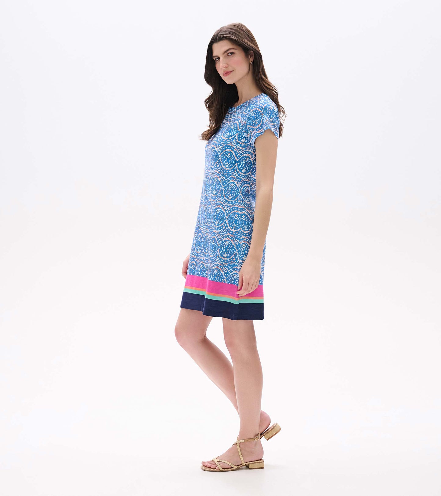 Side view of blue and white ikat tee dress with short sleeves and multicolor striped hem