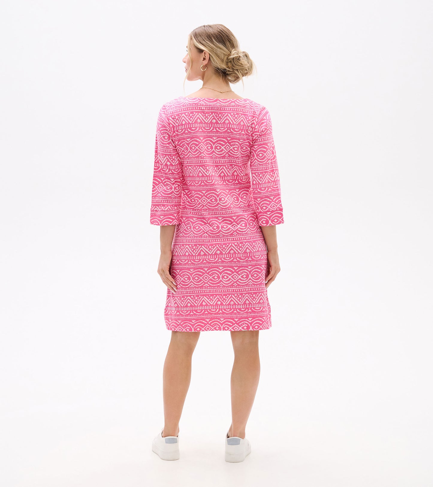 Back view of a pink knee-length dress with white geometric print, three-quarter sleeves, and a notch neckline