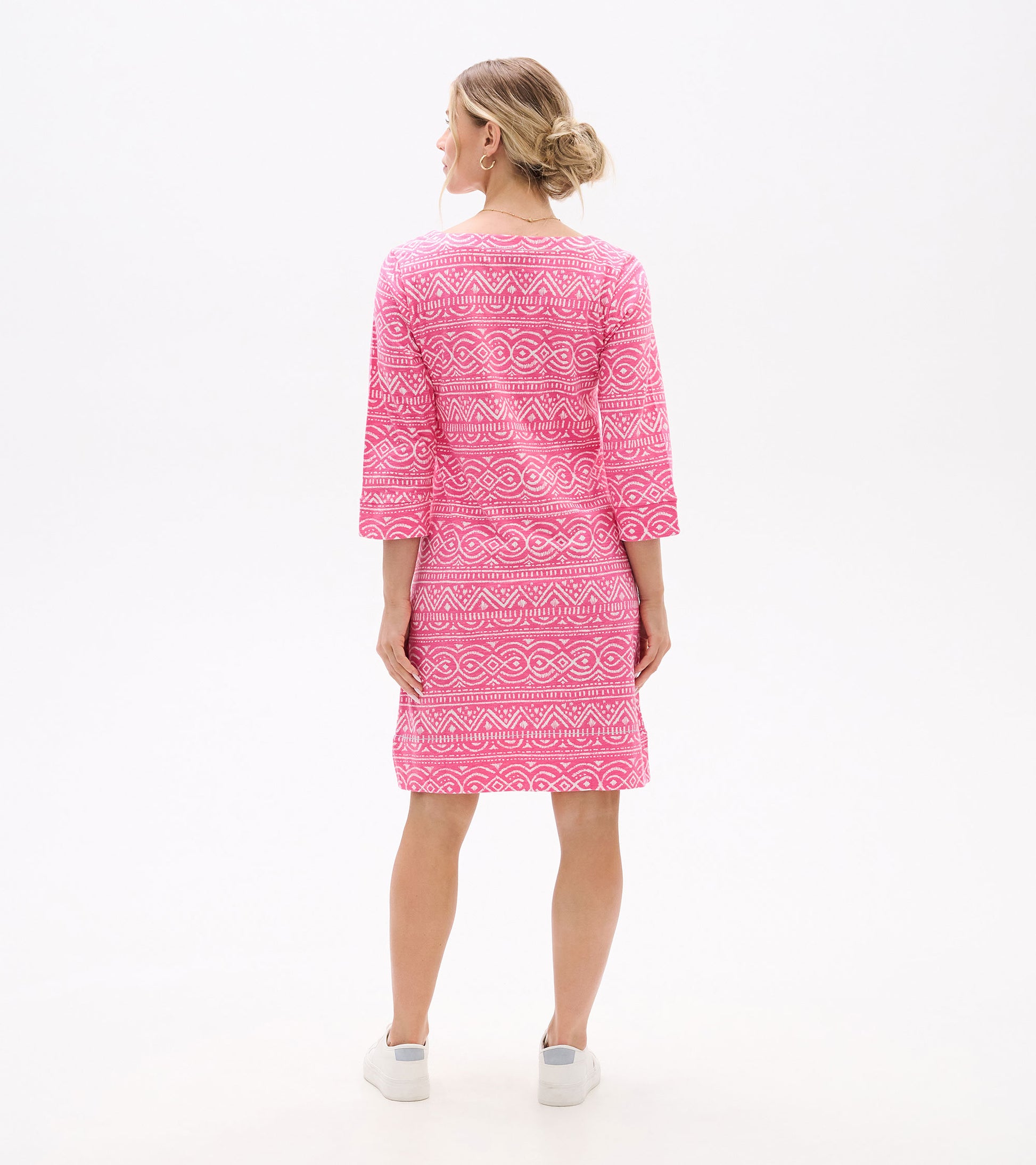 Back view of a pink knee-length dress with white geometric print, three-quarter sleeves, and a notch neckline