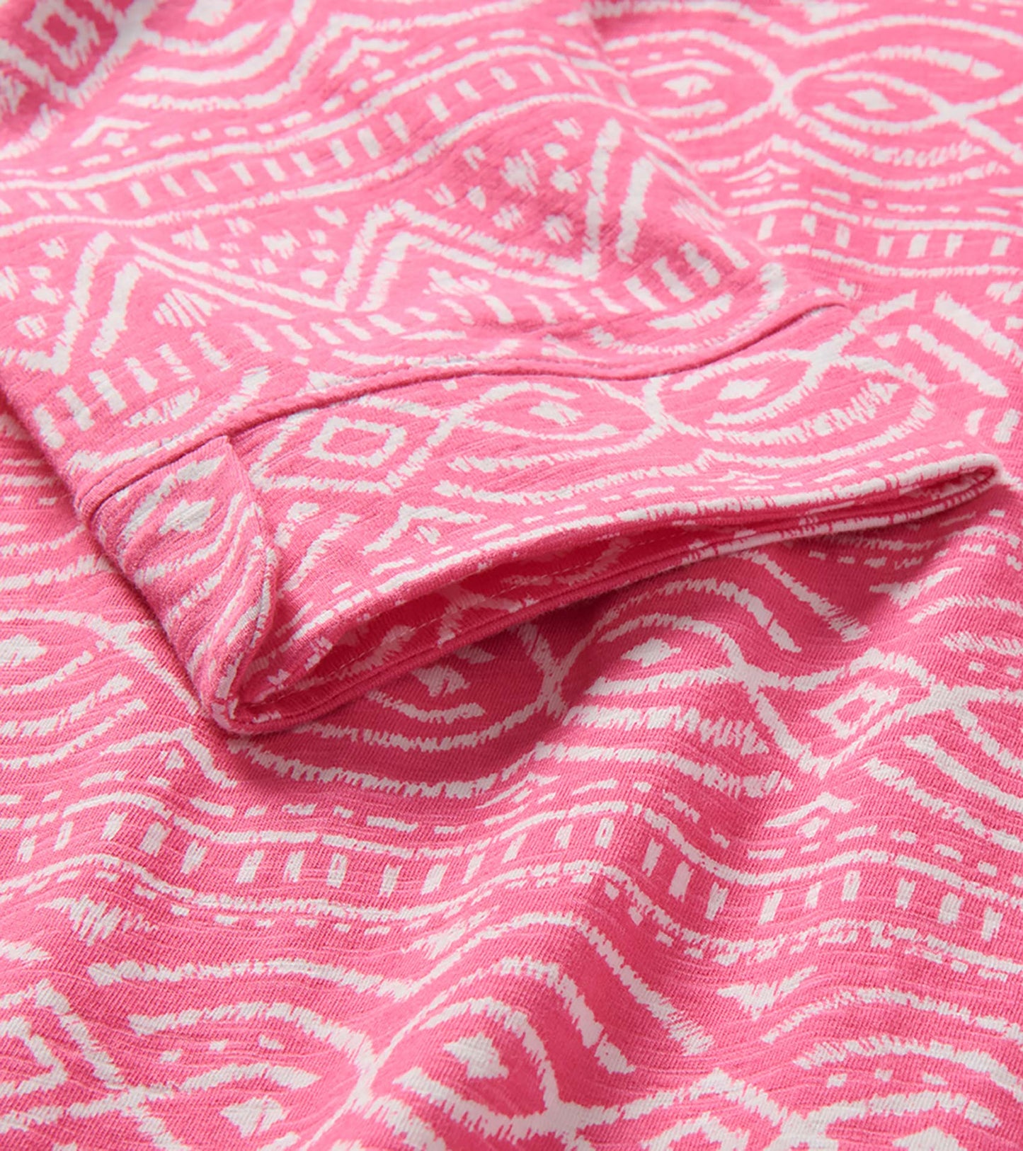 Pink and white patterned knit dress fabric with folded sleeve detail and wavy sketched lines print