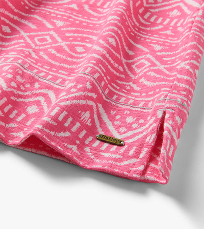 Pink and white patterned knit dress hem with side slit and small metal logo plaque