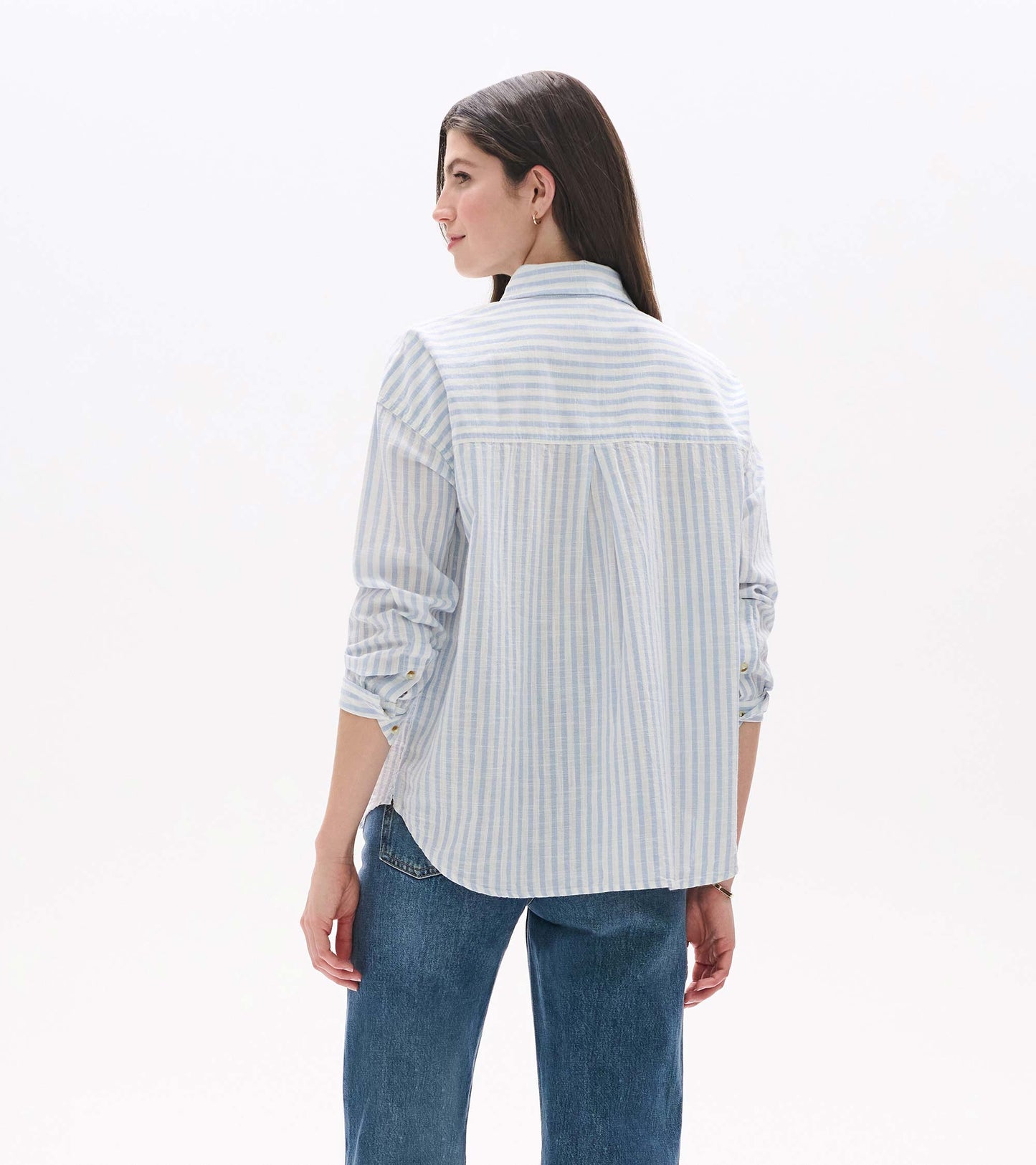 Back view of relaxed button-down shirt in cashmere blue and white stripes with curved hem and back pleat