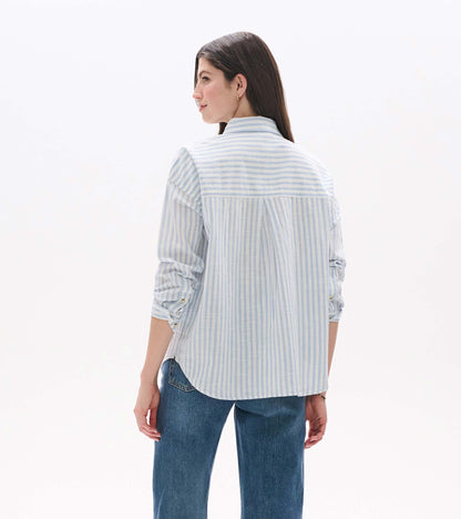 Back view of relaxed button-down shirt in cashmere blue and white stripes with curved hem and back pleat