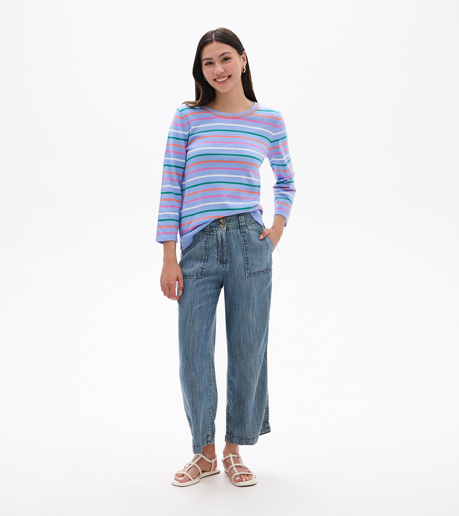 Woman wearing a pastel striped knit top with 3/4 sleeves and round neckline, front view