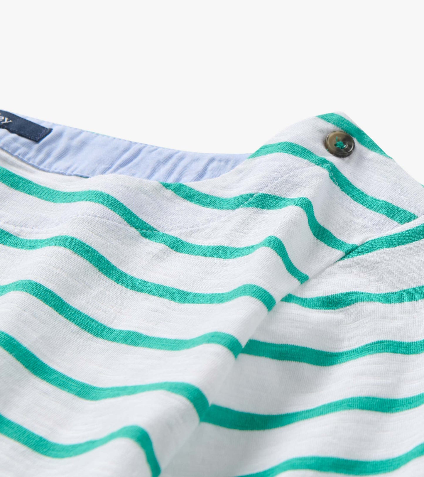 White knit top with teal horizontal stripes and a buttoned neckline detail