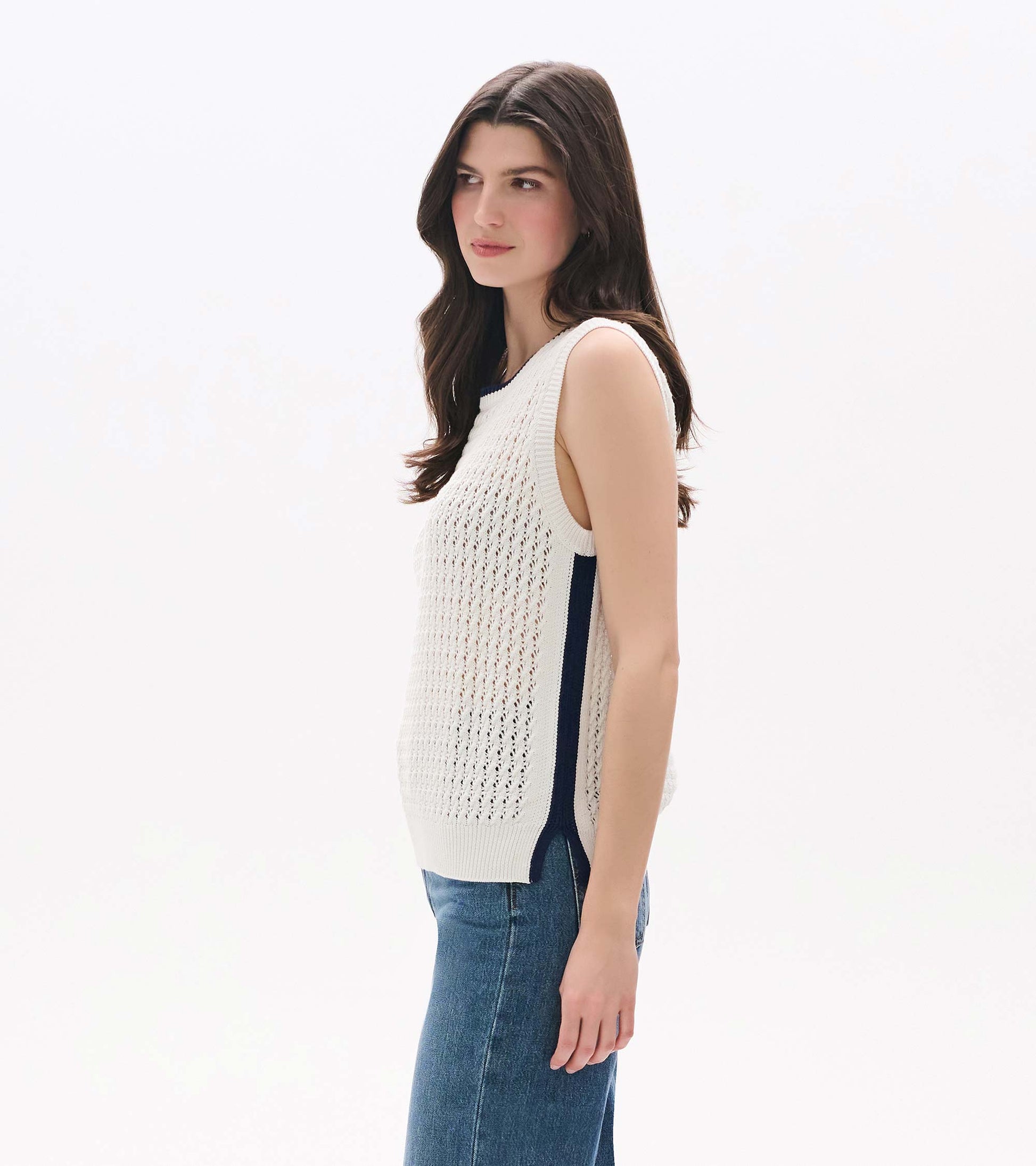 White sleeveless knit tank top with openwork texture, shown on model in side view with blue side trim
