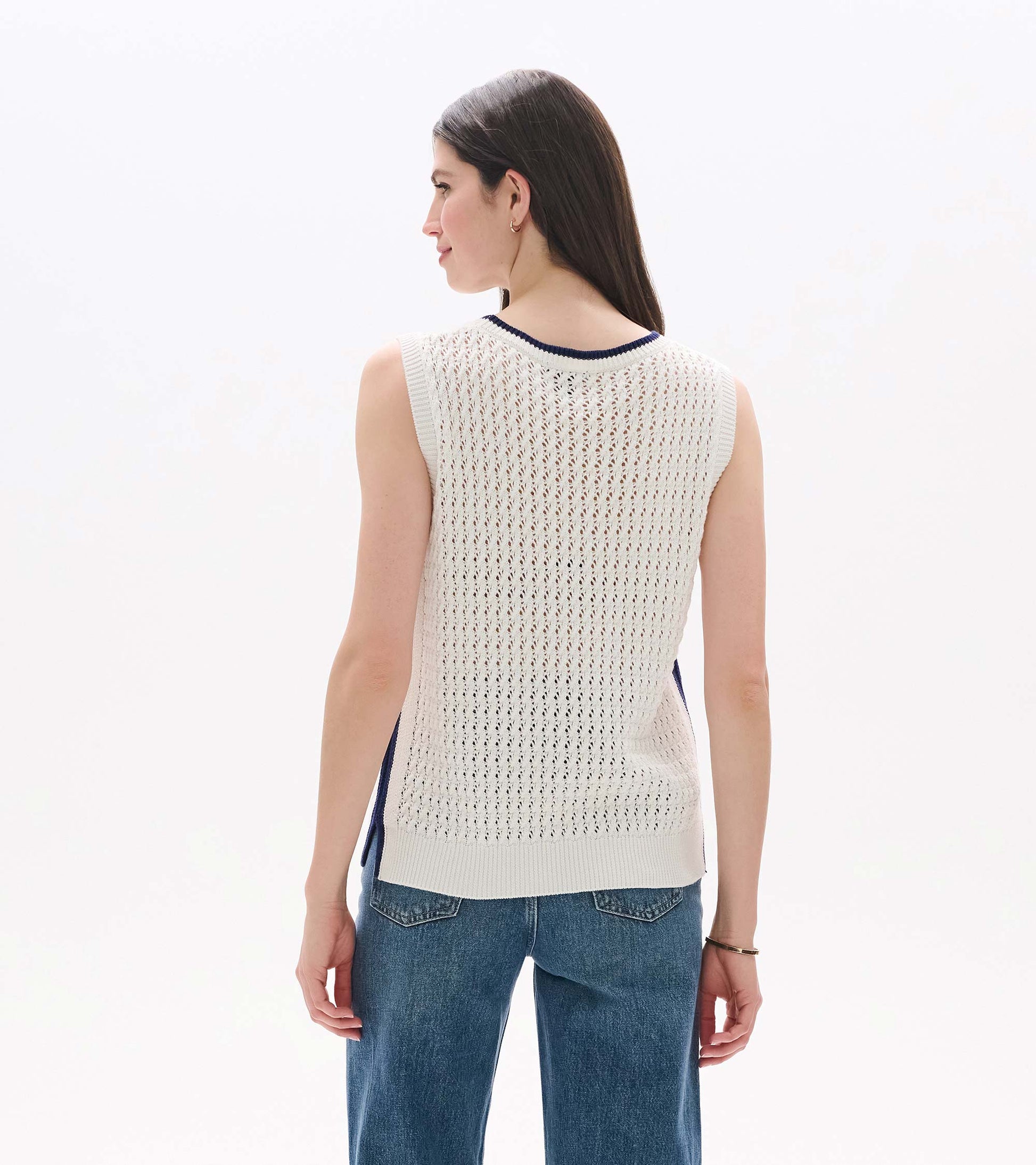 White open-knit sleeveless tank top with navy trim, shown from the back on a model.