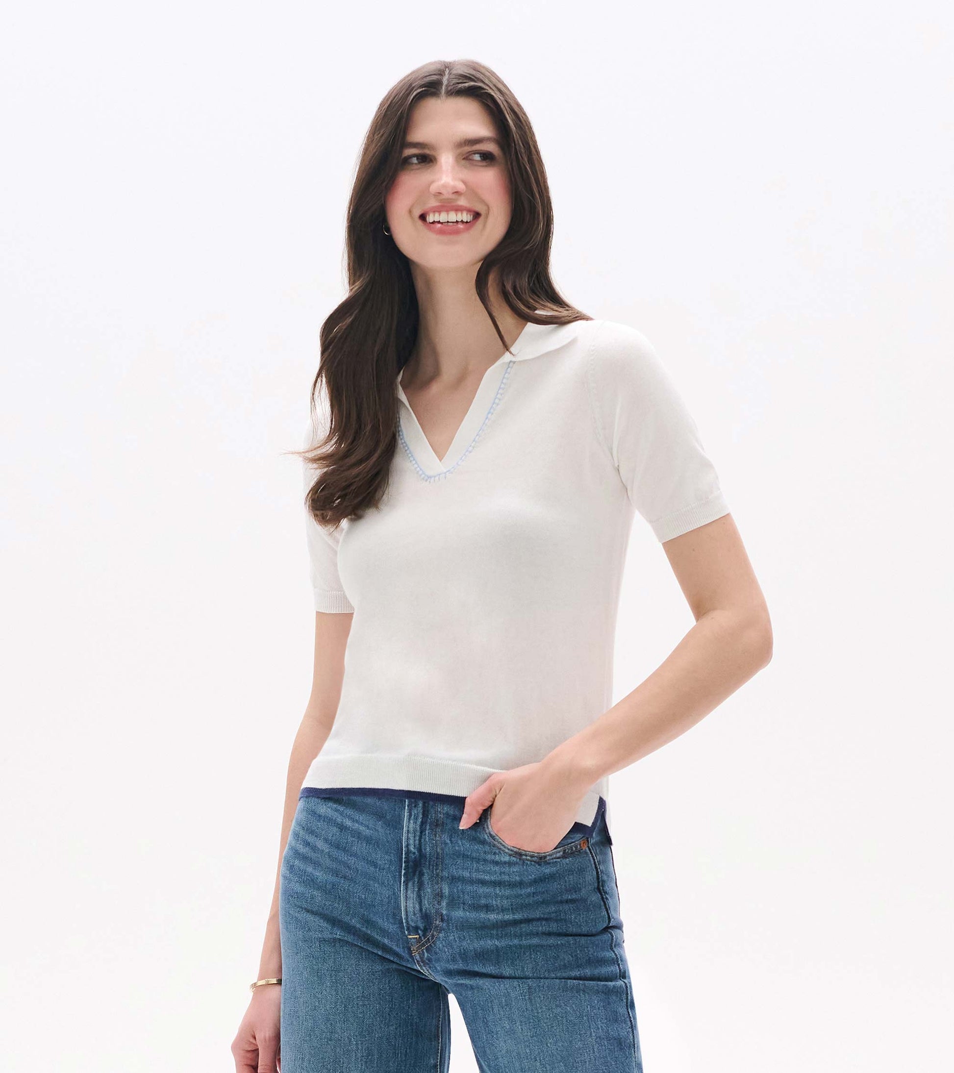 White short-sleeve knit top with Johnny collar and V-neck, worn with blue jeans, front view