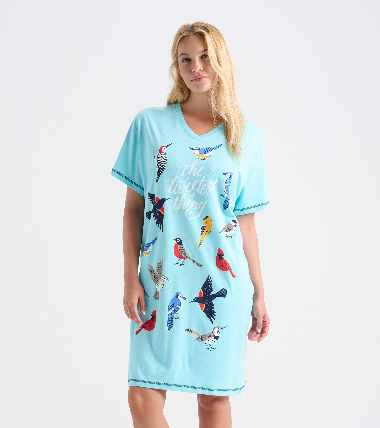 Woman wearing aqua V-neck sleepshirt with colorful bird print and 'The tweetest thing' text