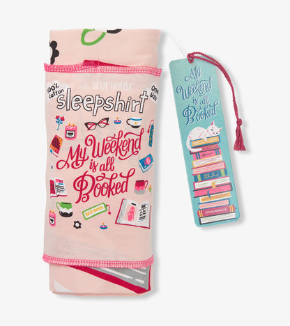 Folded pink sleepshirt with book-themed print and teal bookmark tag with cat on stacked books