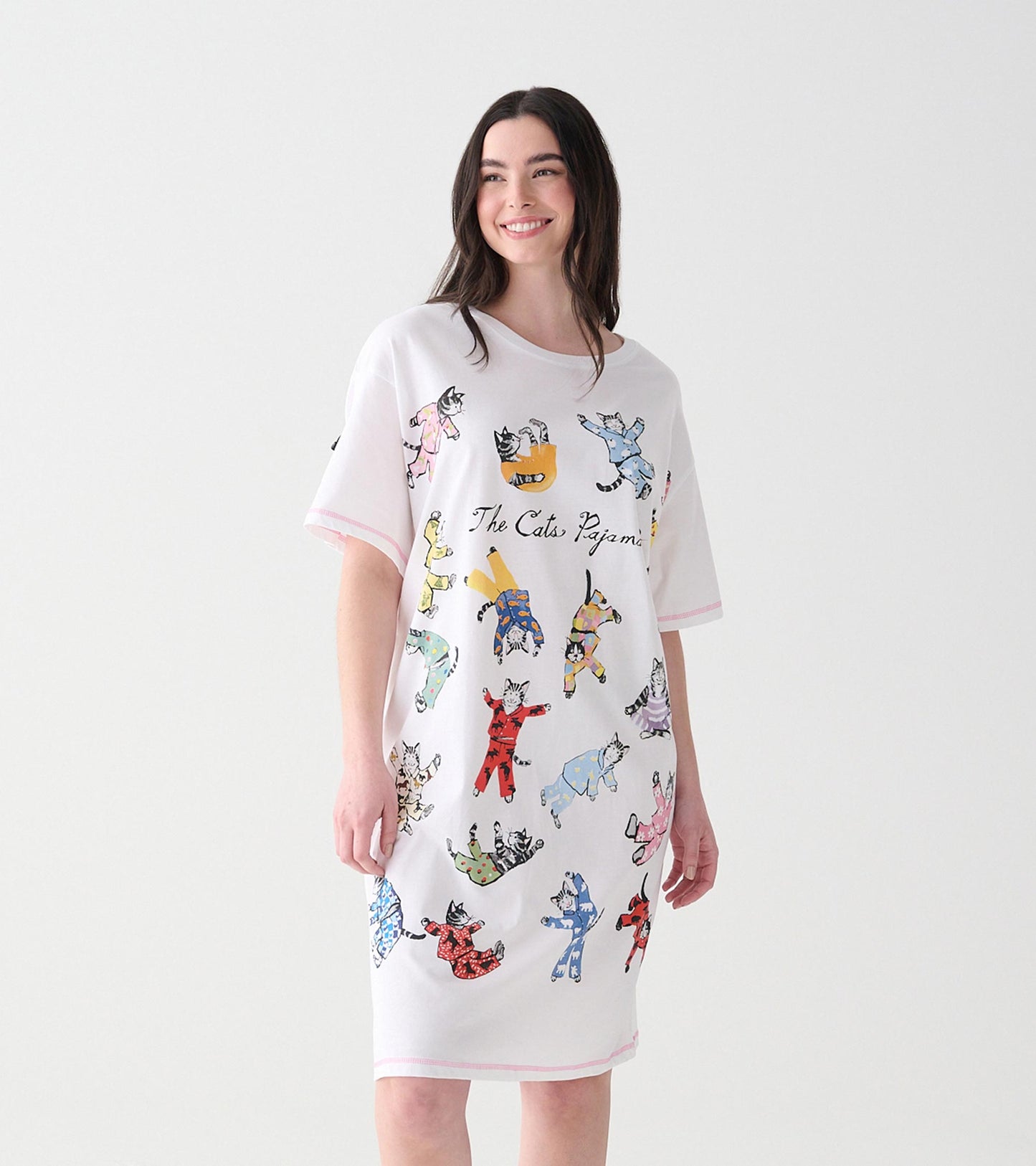 Women's white sleepshirt with colorful cats in pajamas print, shown on model from front